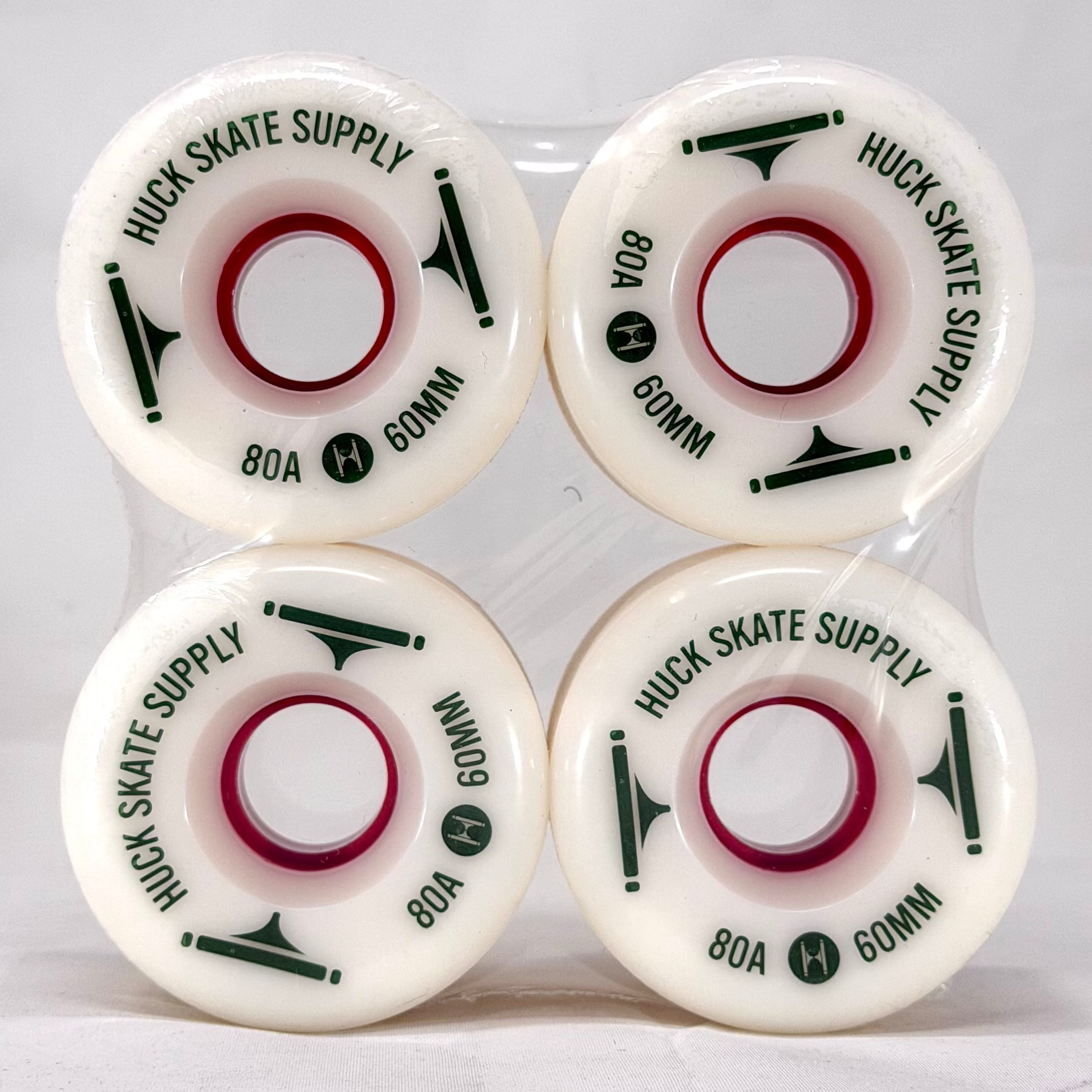 Four white skateboard wheels with green text on a white background