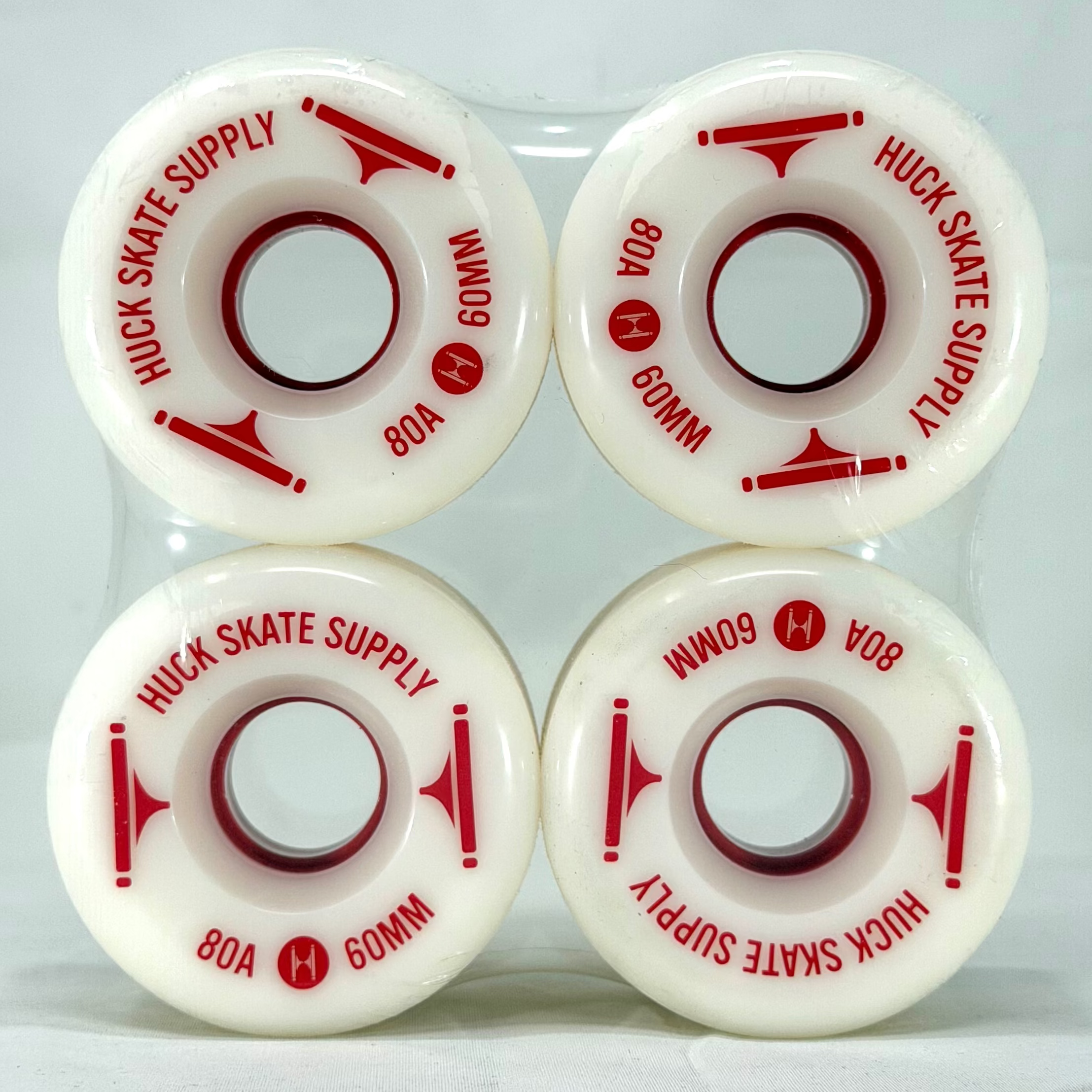 Four white skateboard wheels with red text on a white background